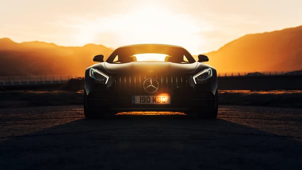 Обои Стильный черный автомобиль Mercedes-AMG GT C на фоне заката