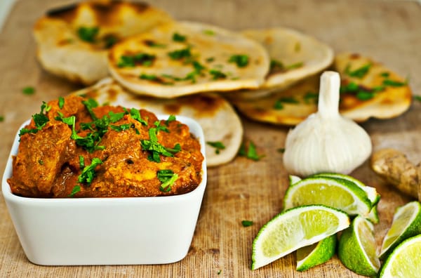 Обои Мясное блюдо на столе с лепешками,кусочками лайма и чесноком