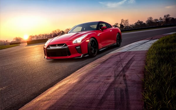 Обои Красный автомобиль Nissan GT-R 2018 года на трассе на закате