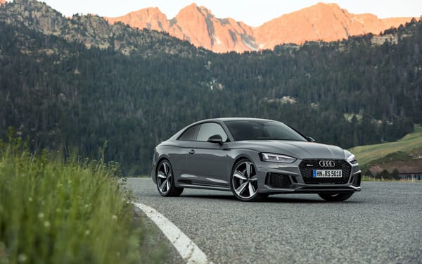 Обои Серебристый автомобиль Audi RS5 2018 года на фоне гор